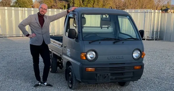 Bald Man Posing Next to a Suzuki Carry kei truck